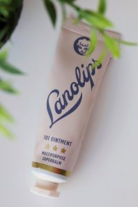 A tube of pink Lanolips ointment on a white background.