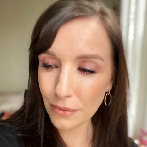 Christmas party makeup ideas using the Huda Beauty Mercury Retrograde eyeshadow palette. This fair skinned, brunette woman wears a lilac smokey eye look.