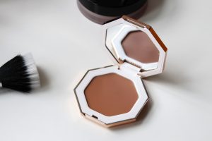 Fenty cream bronzer sits open on a white table.