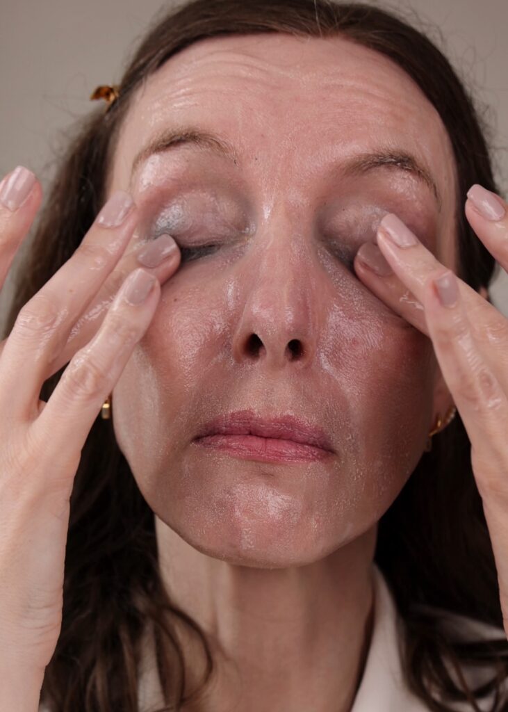 Amy is massaging the cleansing balm with water to form a milk and remove makeup, SPF and dirt