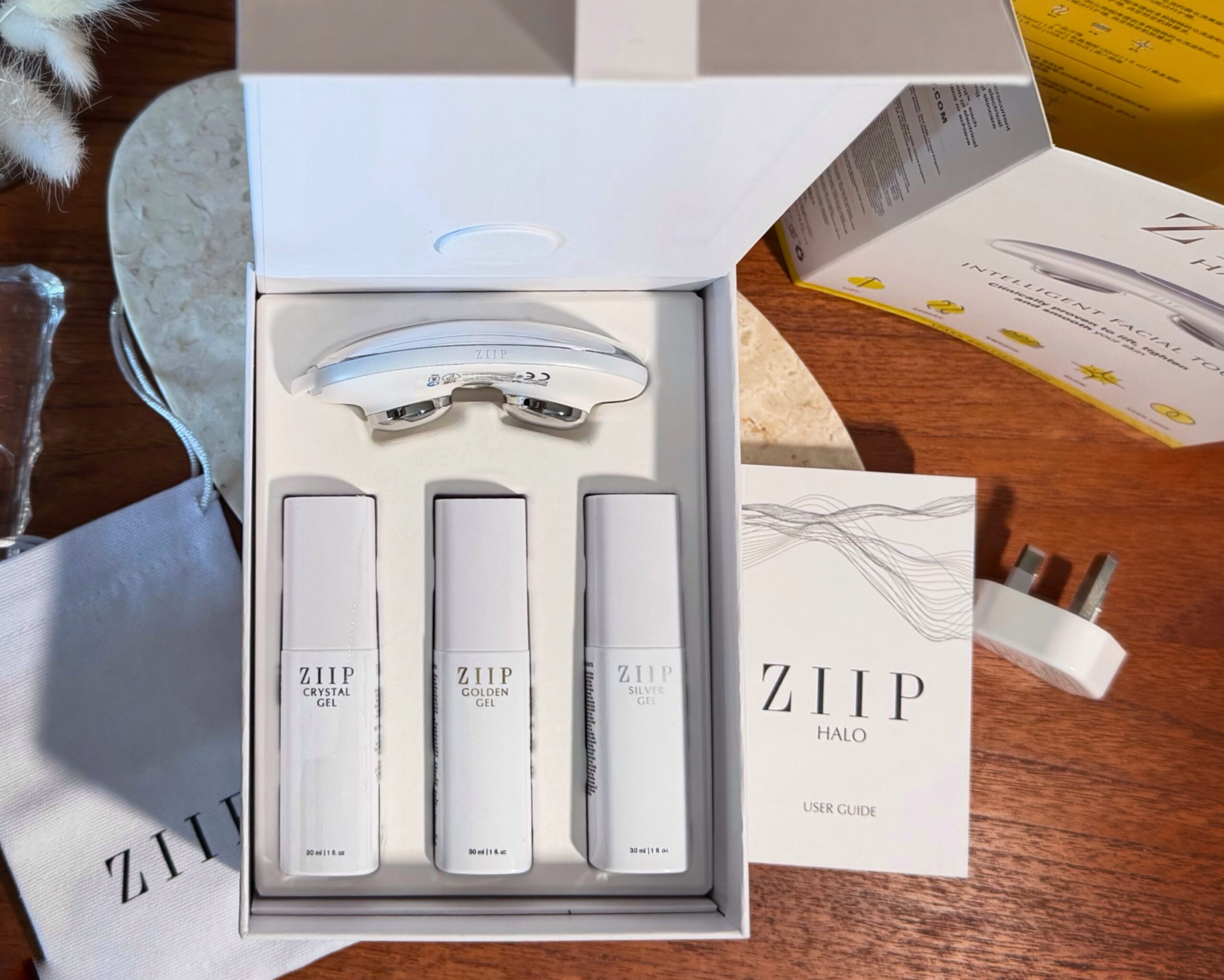 A flat lay of the insides of the ZIIP HALO kit shows the device and 3 bottles of gel